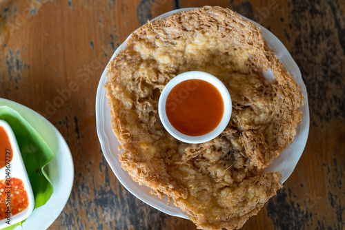 Khai Jeow Moo Sab. A crispy minced pork omelet on wood table