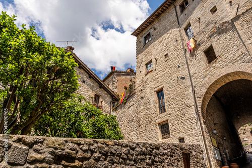 Glimpse of medieval buildings along Via Piccardi, historic stone facades in old town center, Gubbio, Umbria, Italy