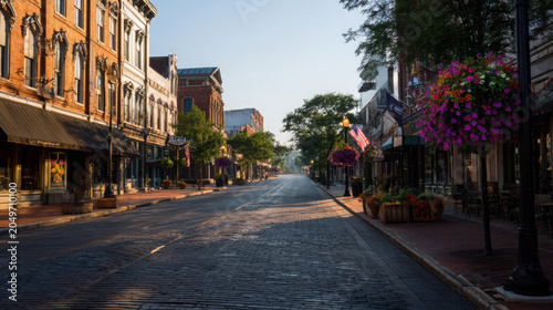 Quiet city street with brick buildings and hanging flower baskets