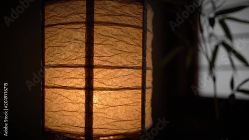 Japanese traditional paper lantern close up in dim light with blurred background, illuminating a serene atmosphere
