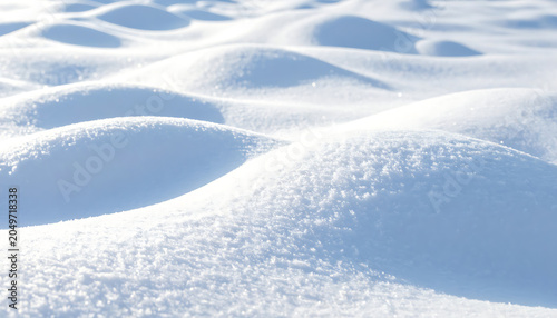 Undulating snow drifts with sparkling frost crystals, winter landscape with soft light and shadows, peaceful serene nature background