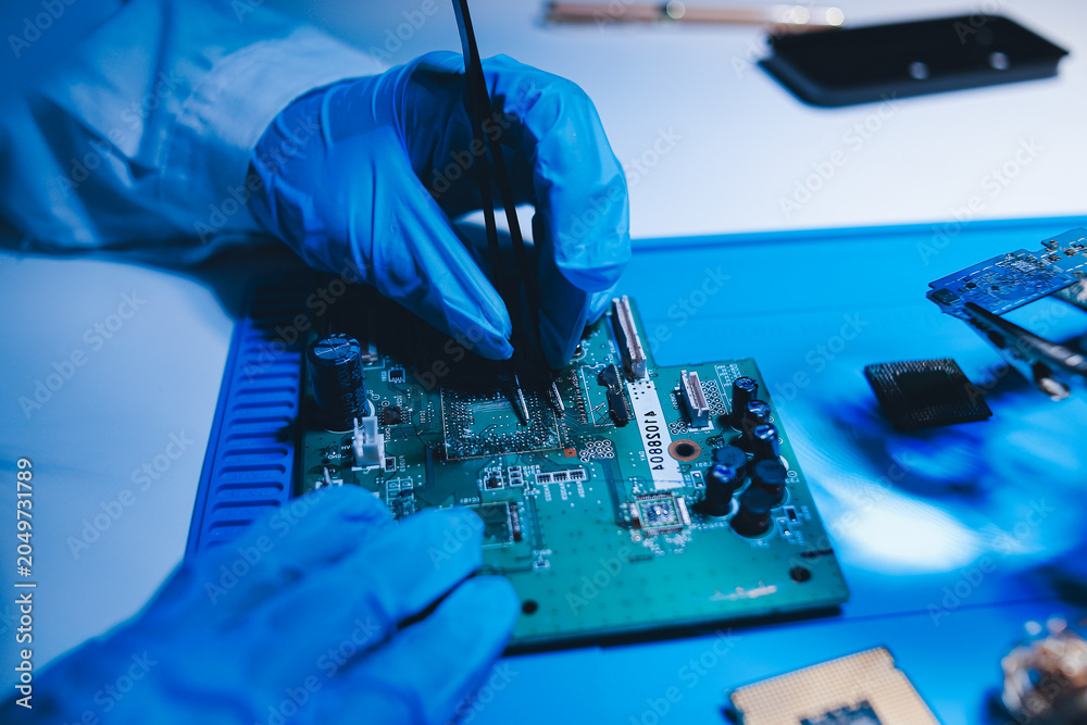 Fototapeta premium Hands in white gloves carefully repair a broken mobile device, meticulously working on the intricate internal electronics and circuit board