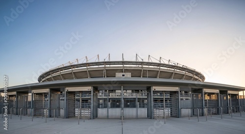 Soccer substitution board displayed outside stadium during evening with clear blue sky and empty parking lot