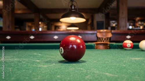 Принти на полотні Close-up of a red billiard ball on a green felt pool table under soft lighting
