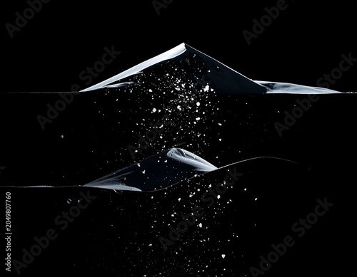 A black background with two shattered glass shards and debris