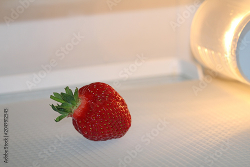 Bild auf Leinwand one ripe strawberry in the refrigerator