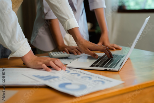 Hands typing on laptop keyboard reviewing market competitor overview data and financial reports during professional business analysis process