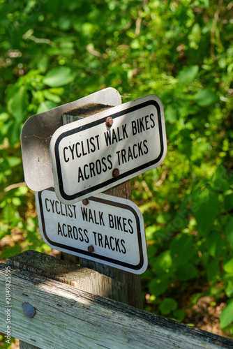 Cyclists are asked to walk bikes across the tracks in a green area
