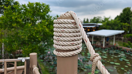 Photography Wooden post with rope wrapped around, knotted end