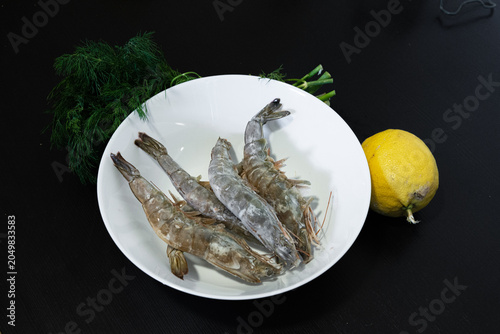 Cooked shrimp served on a white plate. Shrimp cooking in boiling water. Raw shrimp on a white plate