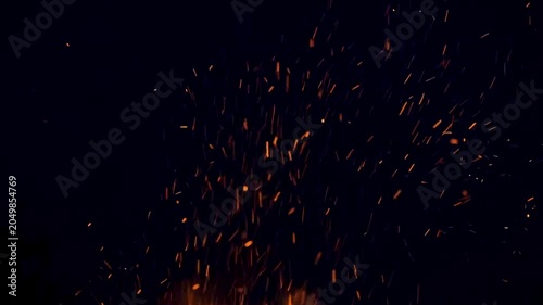 Cinematic fire flames with glowing embers and flying sparks rising against a deep black background, perfect for intense overlays and dynamic visual effects.