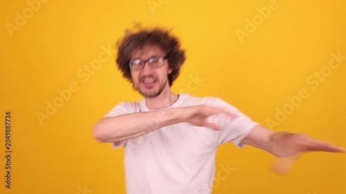 Energetic young man celebrating success with raised fists, joyful motion and bright yellow backdrop conveying strong positive emotion, confidence and motivation for commercial achievement themes