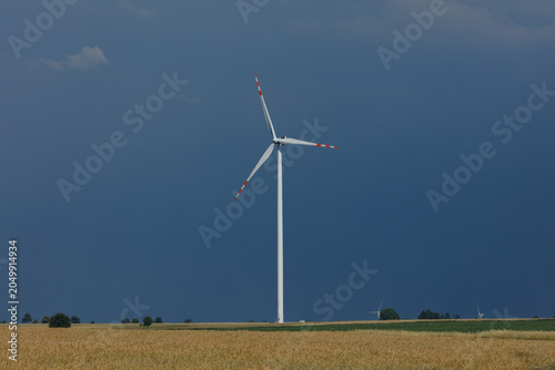 Single wind turbine in a field under a dark sky