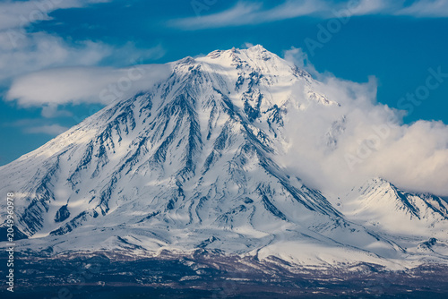 Foto a winter volcano is powerful against the backdrop of a blue sky