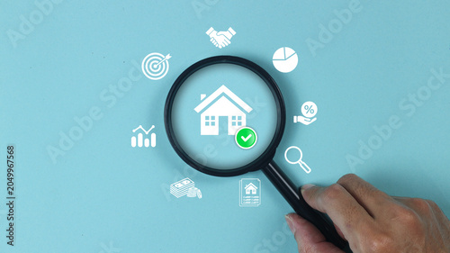 Analyzing real estate investment with a magnifying glass to inspect property value, housing market trends, mortgage growth, financial planning, and home insurance metrics for asset management