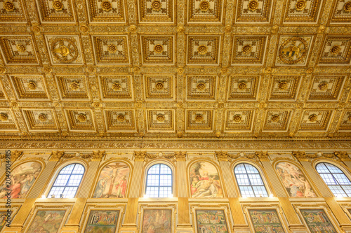 Santa Maria Maggiore basilica central nave interior view, Rome Italy. Golden coffered ceiling ancient columns and mosaics landmark perspective
