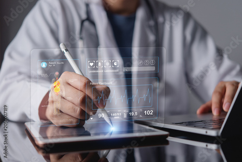 Fotografía Doctor hands using stylus pen on tablet with futuristic virtual patient dashboard hologram medical data interface electronic health record EHR concept of digital healthcare technology MedTech