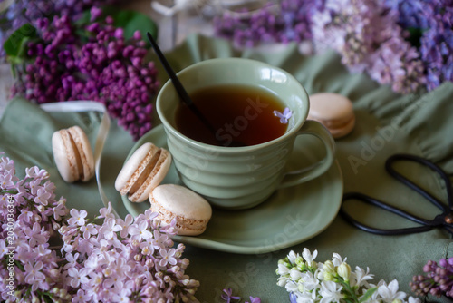 Foto Spring flowers lilac, jasmine, bird cherry, rose hips, roses, peonies, poppies and lilies of the valley, tea and coffee in beautiful porcelain and ceramics