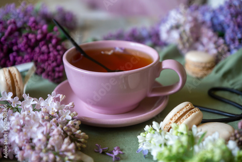 Valokuva Spring flowers lilac, jasmine, bird cherry, rose hips, roses, peonies, poppies and lilies of the valley, tea and coffee in beautiful porcelain and ceramics
