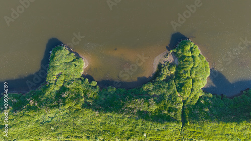 Foto Top down aerial view of a green riverbank and dark river water