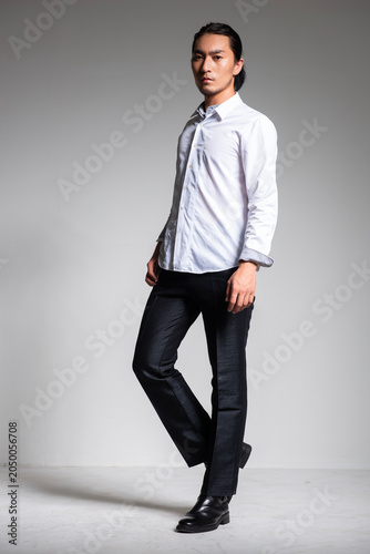 Foto Studio portrait of a handsome Asian man with long hair.