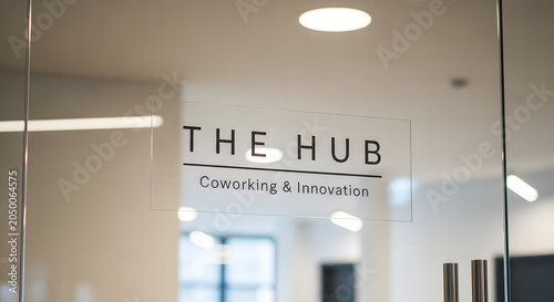 Sleek text typography sign for The Hub Coworking and Innovation on a glass door office background
