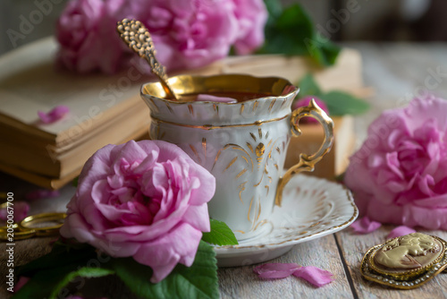 Schilderij op canvas Spring flowers lilac, jasmine, bird cherry, rose hips, roses, peonies, poppies and lilies of the valley, tea and coffee in beautiful porcelain and ceramics