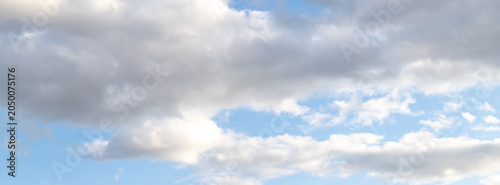 Banner white cumulus clouds on a clear blue sky.