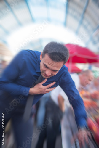 Fainting businessman falling down and losing balance during heart attack with copy space