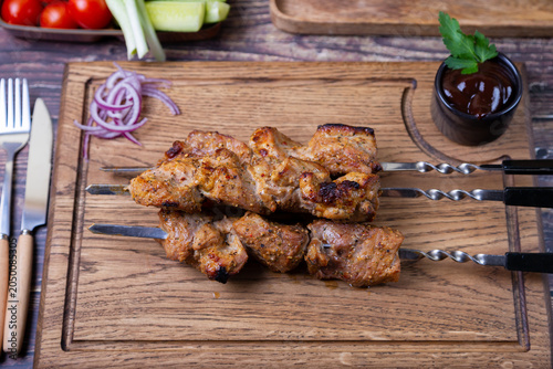 Traditional Russian shashlik on skewers with vegetables. Grilled pork meat (shish kebab). Close-up.