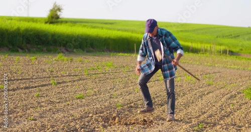 Man crouching in plowed farmland working close to the soil