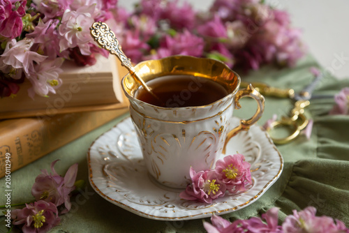 Spring flowers lilac, jasmine, bird cherry, rose hips, roses, peonies, poppies and lilies of the valley, tea and coffee in beautiful porcelain and ceramics.