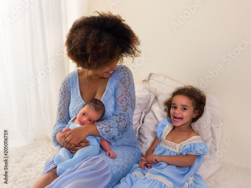 African newborn baby with Mama and sister