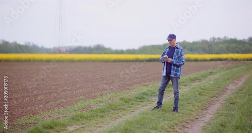 Man observing farmland from a grassy rural path