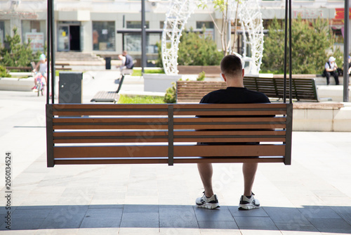 Loneliness. A man sitting alone on a bench.