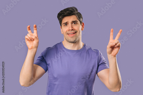Tableau sur toile Skeptic young man With Hands Two Fingers Air Quotes On violet, Sarcasm,Cynicism