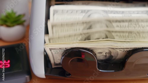 A cash counting machine effortlessly sorts bills while a gentle hum fills the air. Sunlight streams in as each note is neatly arranged, showcasing efficiency in action