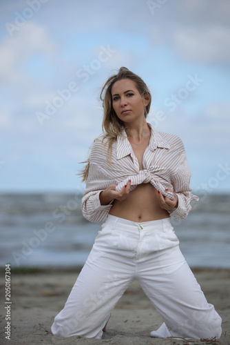 Young Woman Posing on Beach in Striped Shirt
