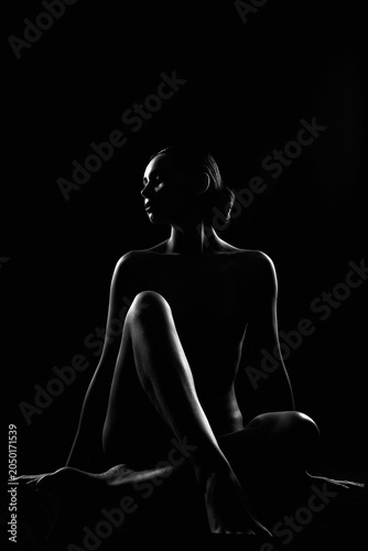 Nude Woman silhouette in the dark. Beautiful Naked Body Girl