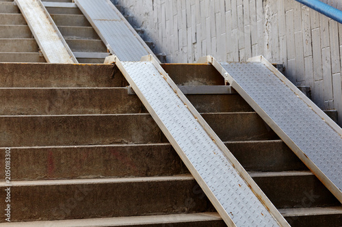 Metal ramp on the stairs in the underground passage in the city. A metal ramp used for wheelchairs or baby stroller to move up and down in Kyiv, Ukraine
