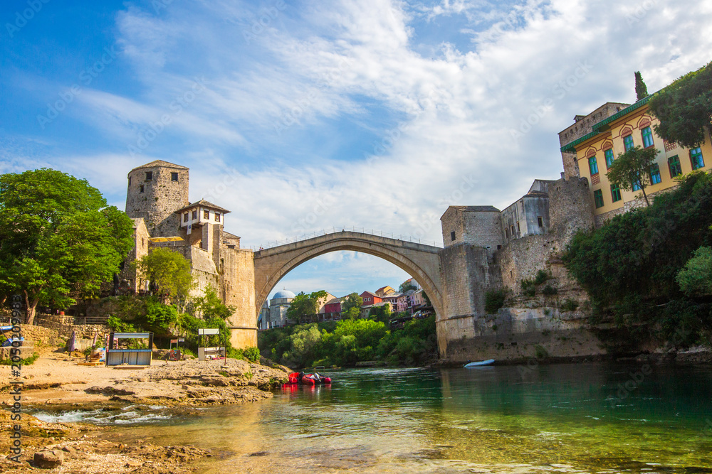 Obraz premium Historic Mostar Bridge Stari Most Over Neretva River on a Sunny Day in Bosnia and Herzegovina