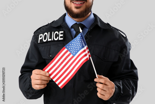 Police officer with USA flag on light background. Labor Day celebration