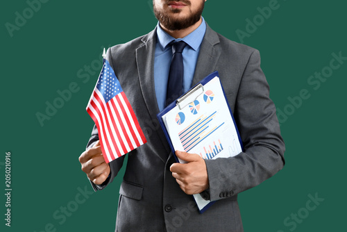Young businessman with clipboard and USA flag on green background. Labor Day ...