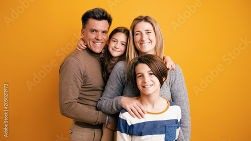 Photos Family portrait showing parents and two children smiling, embracing, and posing