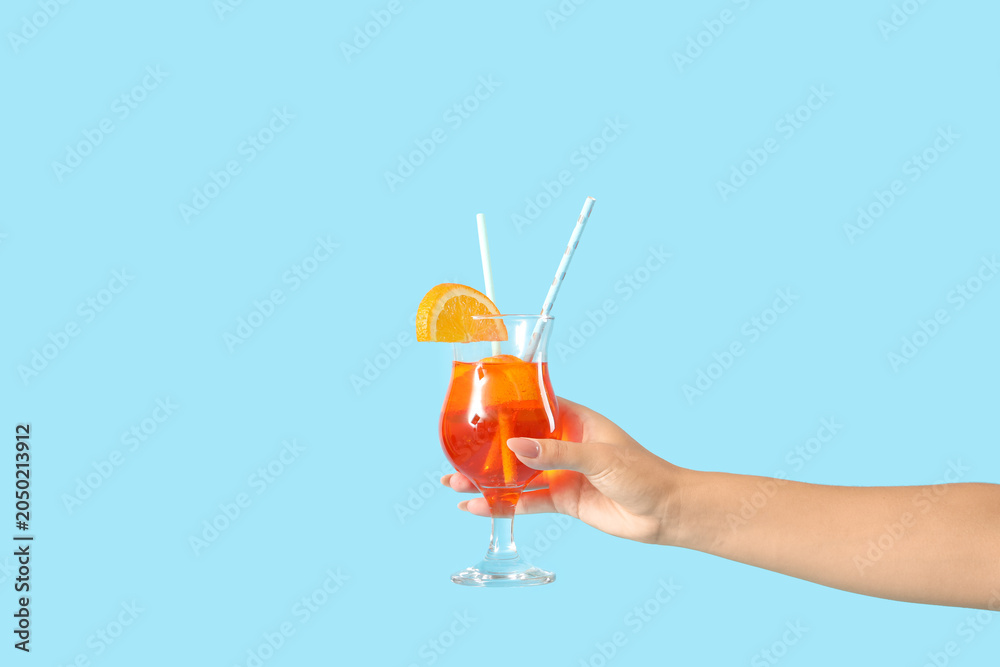 Obraz premium Young woman with aperol spritz cocktail on blue background