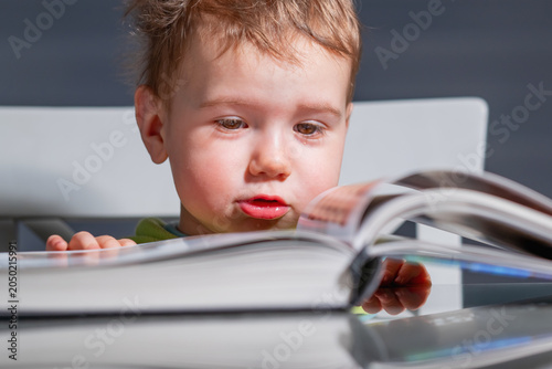Little reader fascinated by the pages of an open book.