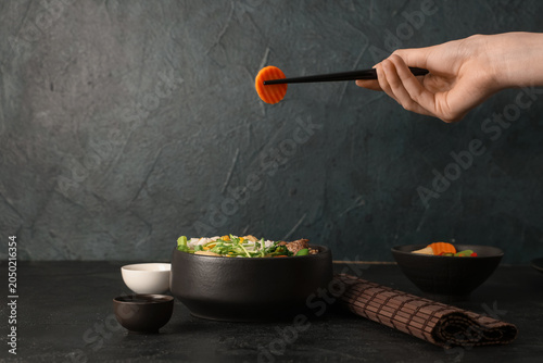 Female hand with chopsticks...