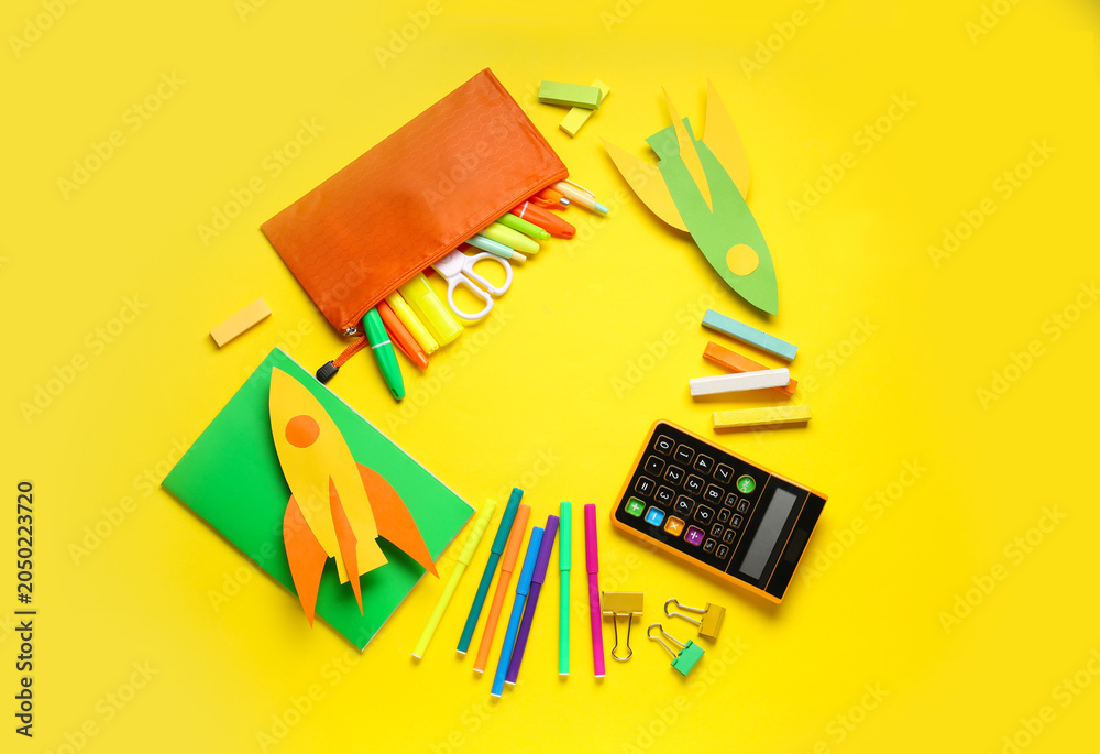 Fototapeta premium Frame made of paper rockets, calculator and different stationery on yellow background