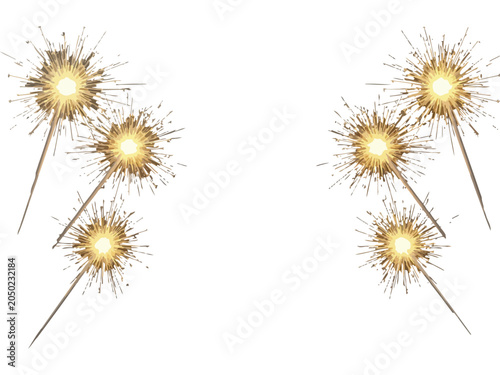 Four lit sparklers with golden trails on white background