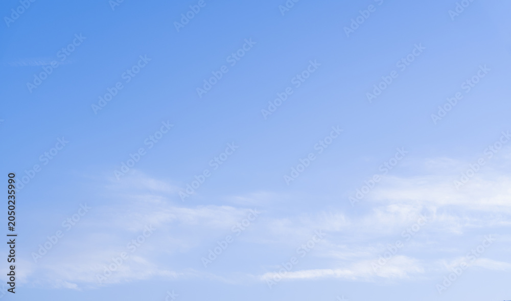 Fototapeta premium Blue sky background with soft white clouds and clear atmosphere. Natural cloudscape texture for weather, summer, nature, travel, banner, wallpaper, advertising and graphic design projects.